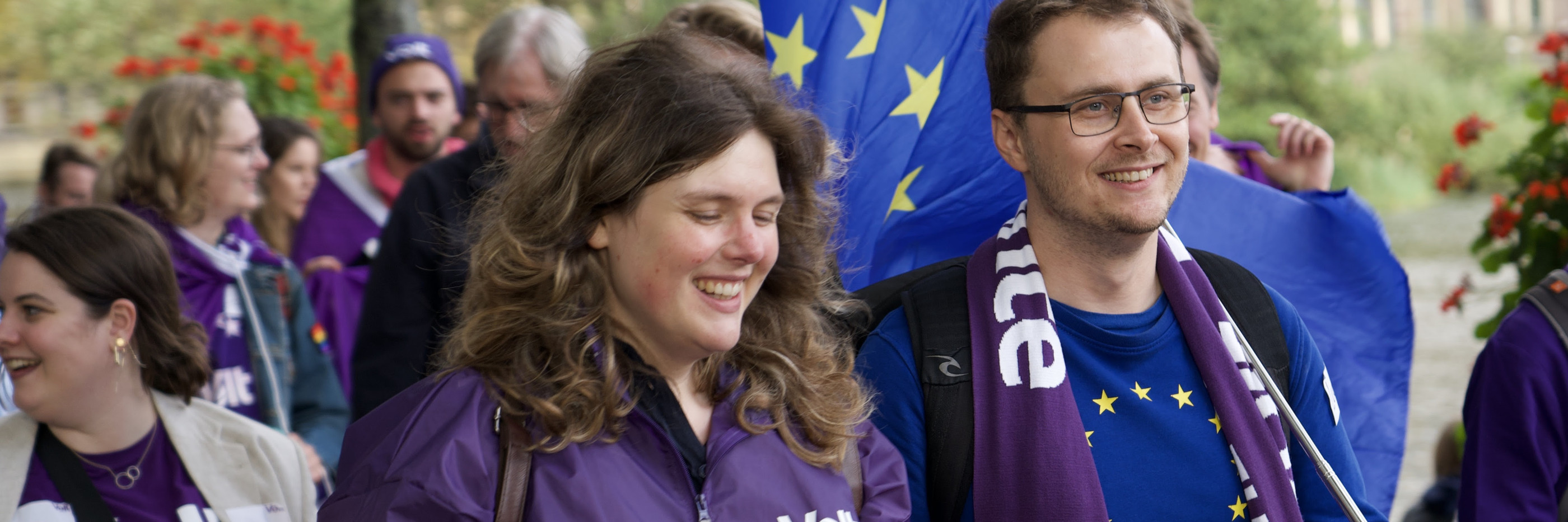 Marieke Koekkoek loopt in de klimaat mars mee. Op de achtergrond zijn mensen paars gekleed met Europa vlaggen.