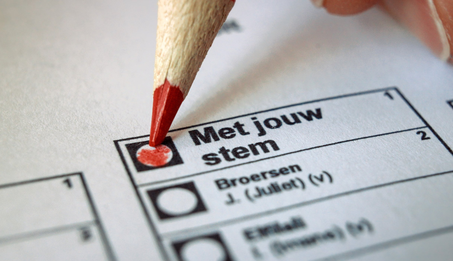 Rood potlood vult stembiljet in op vakje 