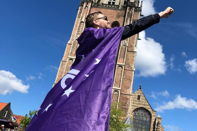 Vrijwilliger draagt volt vlaag als cape en poseert als superheld voor de domtoren