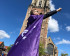 Vrijwilliger draagt volt vlaag als cape en poseert als superheld voor de domtoren