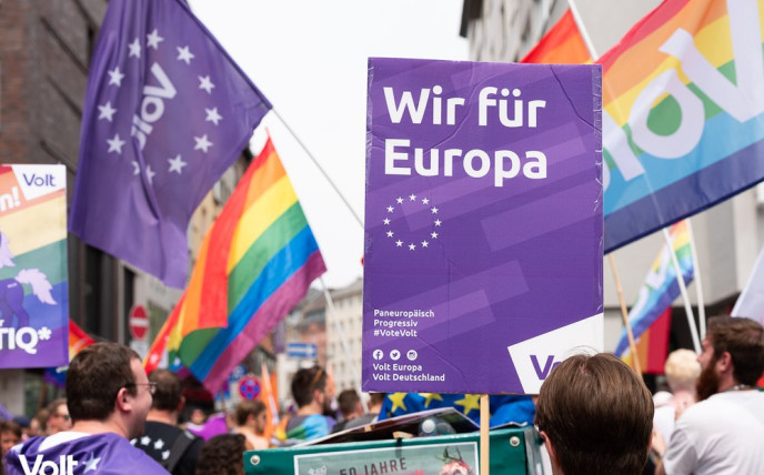 Borden, volt vlaggen en Pride vlaggen. Op een bord staat Wij voor Europa in het Duits