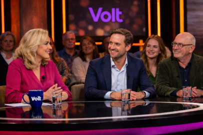 Talkshow setting met Volt logo op mok en achtergrond