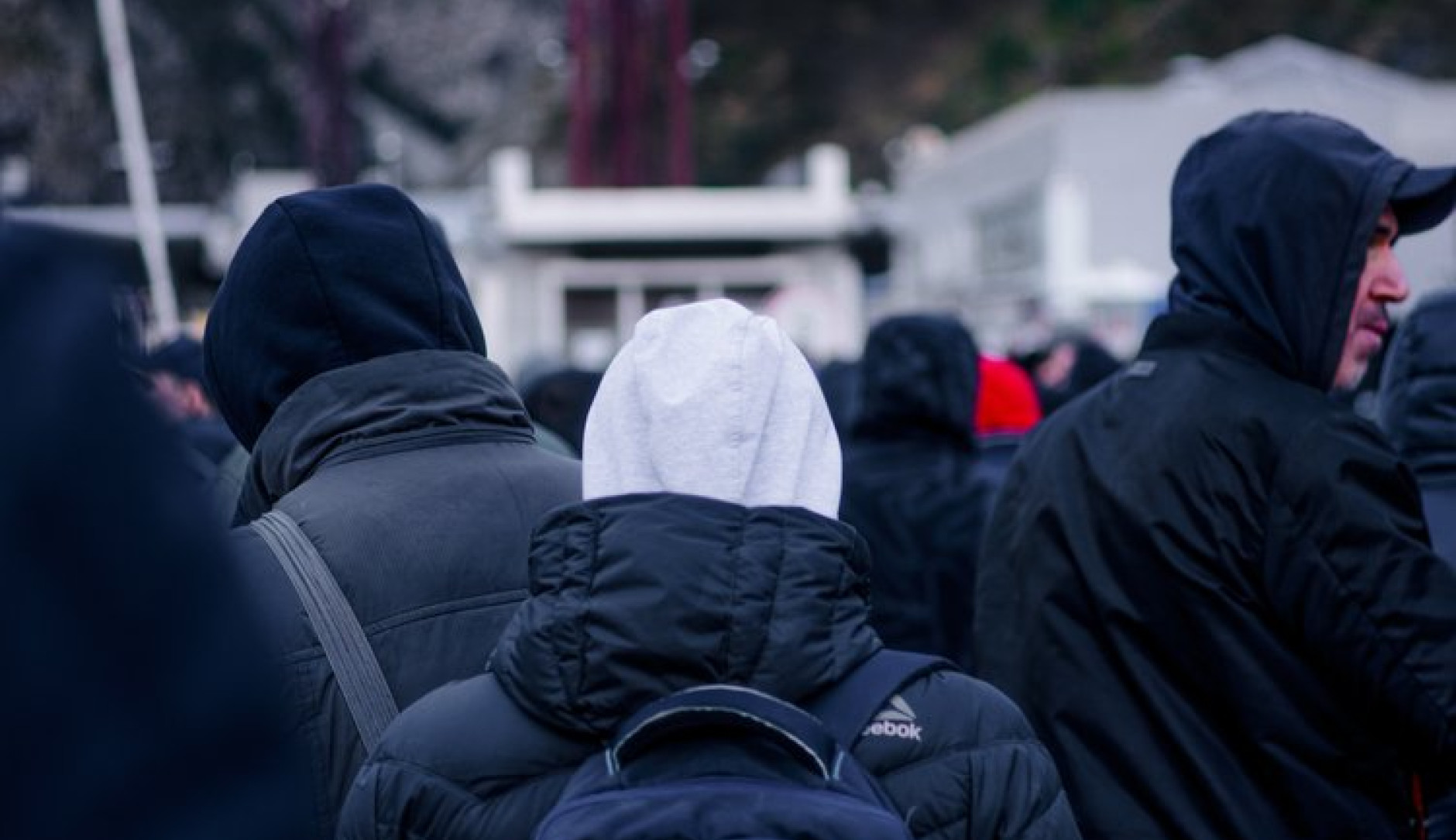 Mensen met rugzakken en capuchons