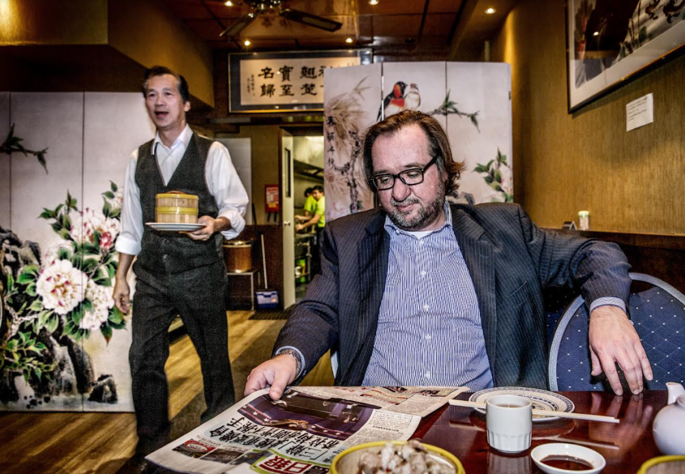 Man in Aziatisch restaurant met krant