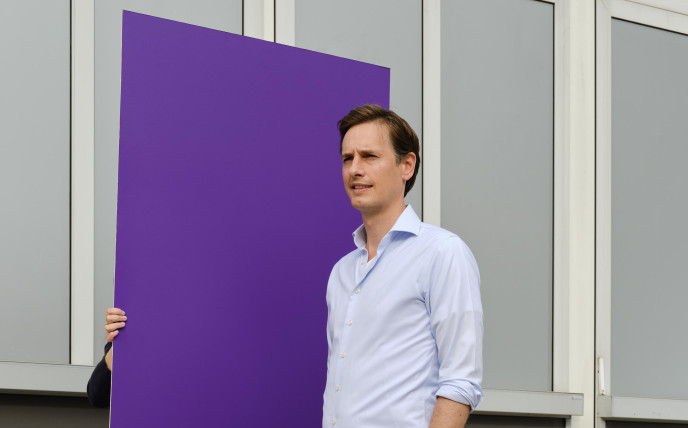 Laurens Dassen loopt mee met een paars bord op straat