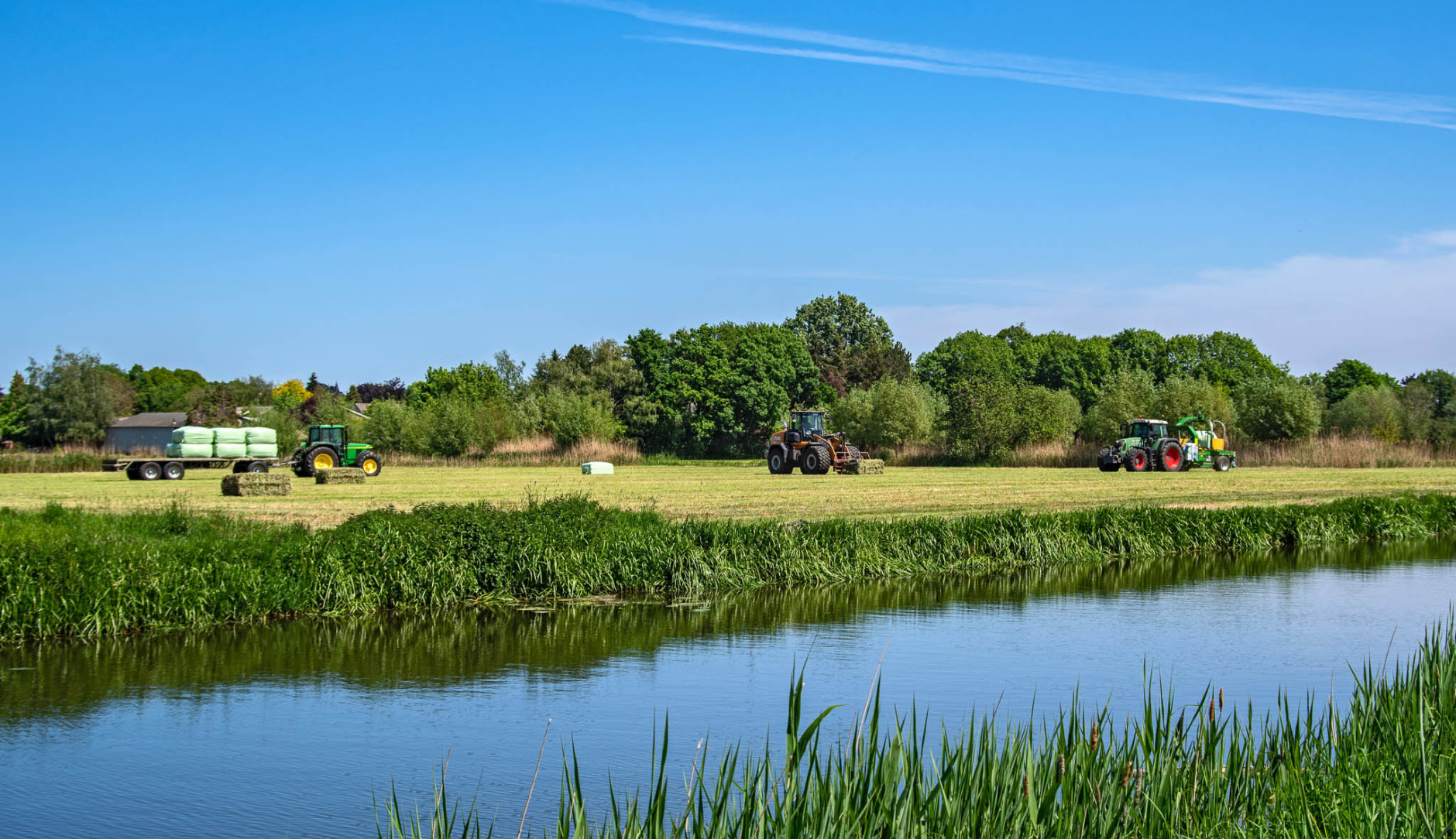 Drie tractoren op landbouw grond