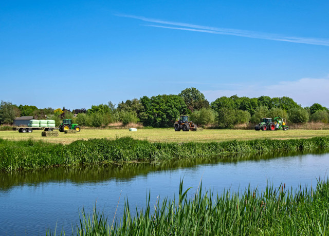 Drie tractoren op landbouw grond