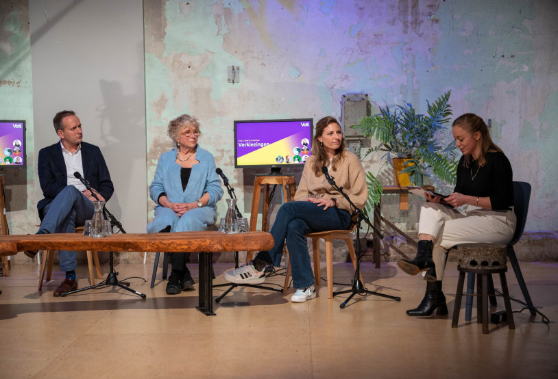 Groep Volters in gesprek aan tafel met een microfoon