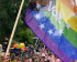Volters op een pride parade. Ze houden een grote pride volg omhoog met het Volt logo er in.