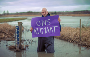 Man in water die paars vel vasthoudt met woorden Ons Klimaat