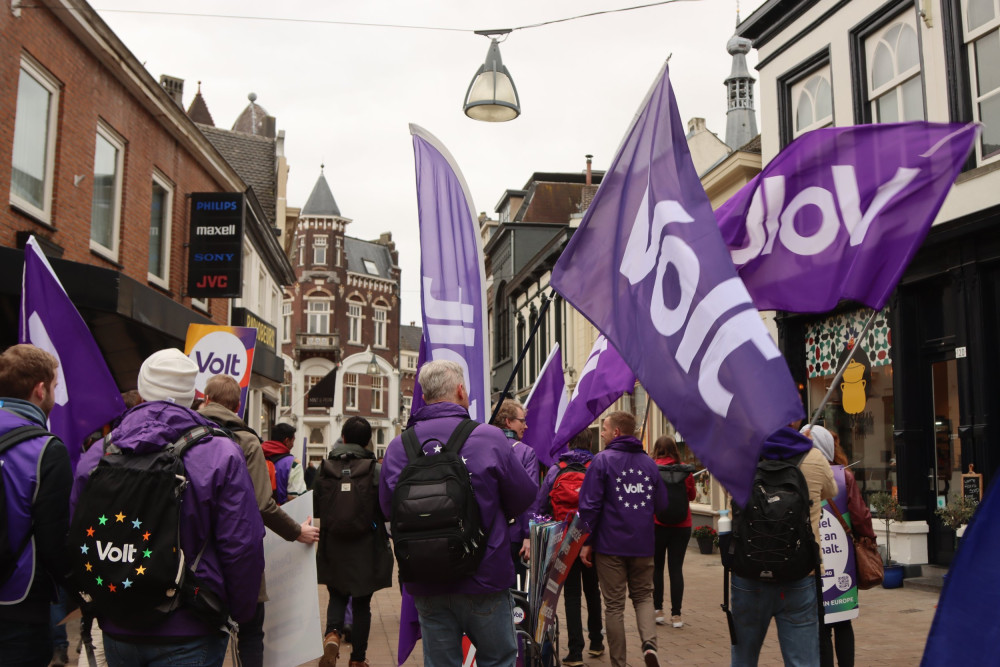 Mensen met Volt vlaggen lopend door de stad