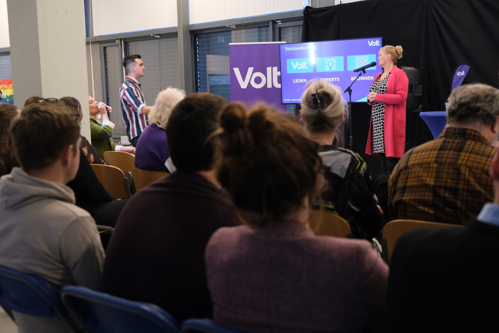 Twee personen spreken een publiek toe.