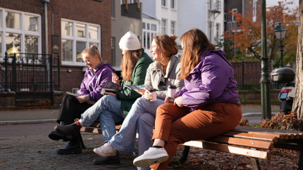 Vier Volt leden in het zonnetje op een bank aan het lachen