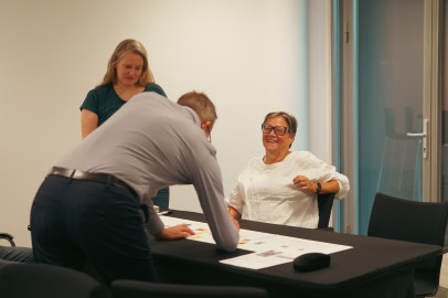 Drie deelnemers van een workshop werken samen aan een tafel