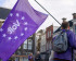 Een Volt-lid van achteren die een paarse Volt vlag vasthoudt