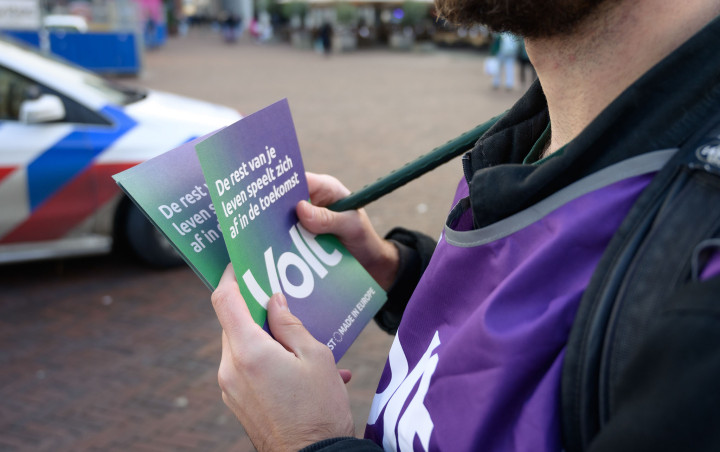 Een closeup foto van een vrijwilliger die Volt flyers vasthoudt