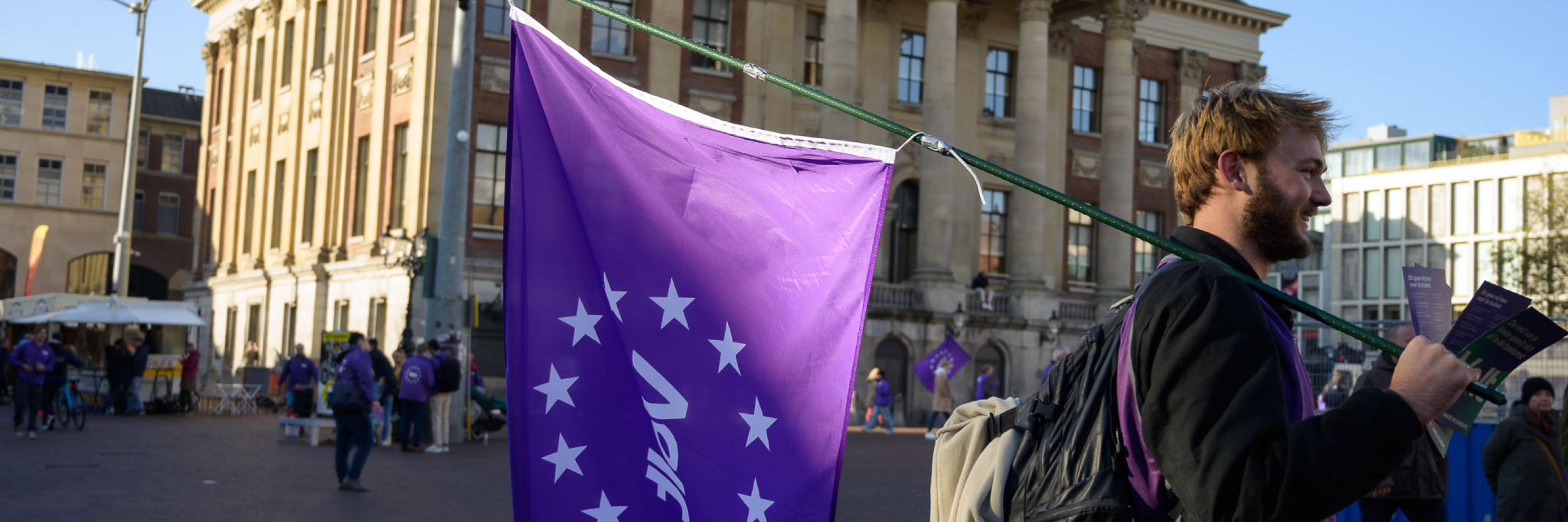 Volter met volt vlag die aan het flyeren is voor het stadhuis in Groningen.